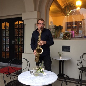 Saxofonist Frank lokt de gasten naar het jubileumfeest.